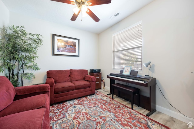living room with ceiling fan, visible vents, a healthy amount of sunlight, and light wood-style floors