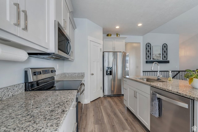 289 W Lauren N, Tooele, UT 84074 - kitchen with appliances with stainless steel finishes, a sink, light wood-style floors, white cabinetry, and recessed lighting