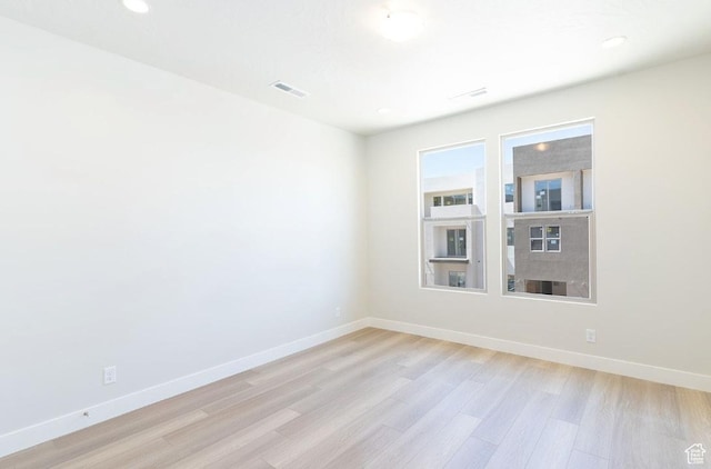 unfurnished room with visible vents, recessed lighting, light wood-style flooring, and baseboards