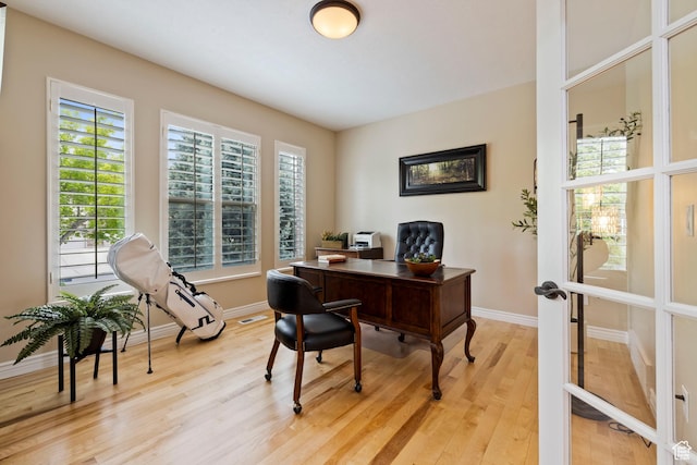 office area featuring baseboards and light wood-type flooring