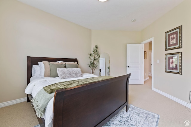 bedroom featuring light colored carpet and baseboards