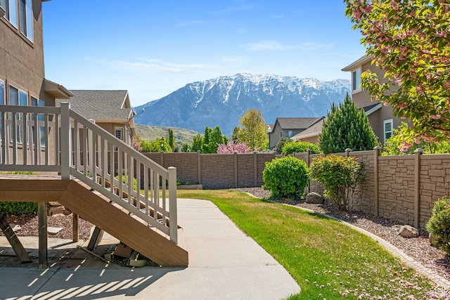 view of yard with a fenced backyard, a patio, a mountain view, and stairway