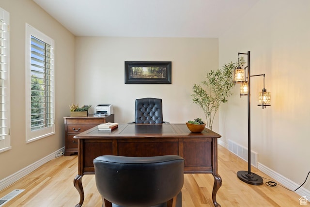 office with baseboards, visible vents, and light wood-style floors
