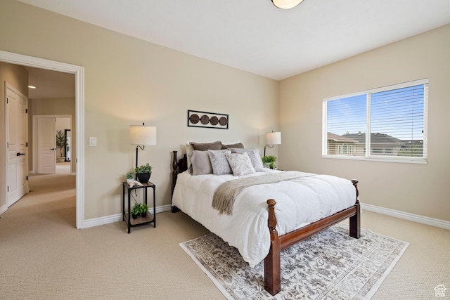 bedroom with baseboards and light colored carpet