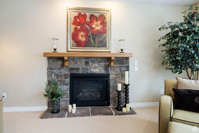 room details featuring baseboards, a stone fireplace, and carpet