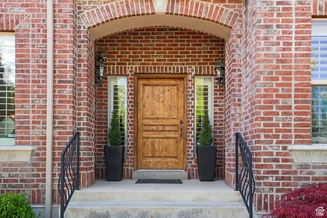 view of exterior entry featuring brick siding