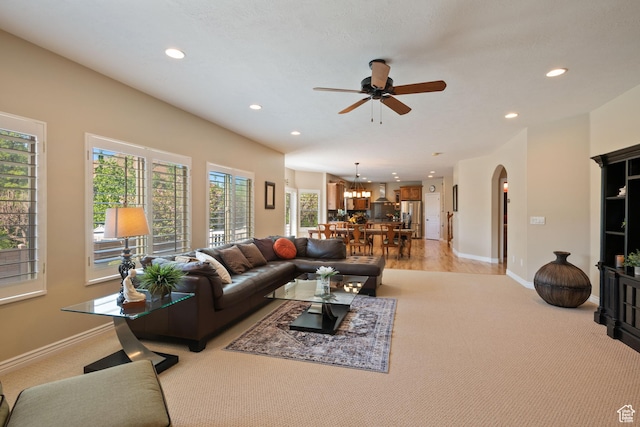 living room featuring a ceiling fan, baseboards, recessed lighting, and arched walkways