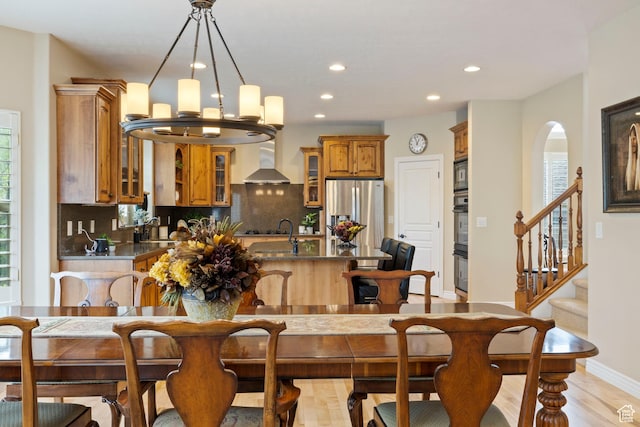 dining area with recessed lighting, baseboards, arched walkways, a chandelier, and stairs