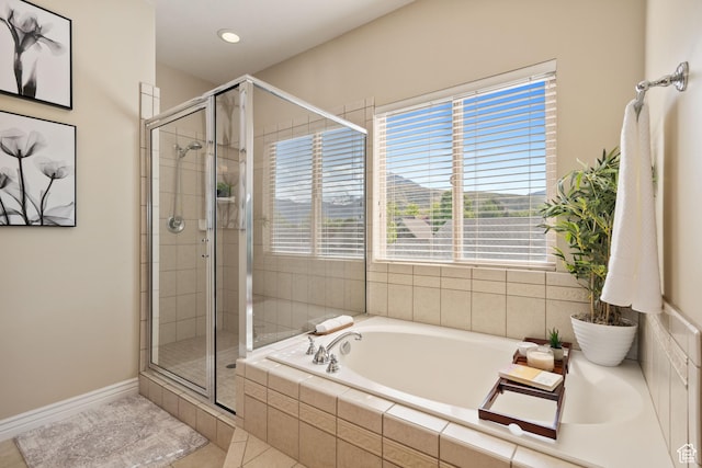 bathroom with tile patterned flooring, a garden tub, a shower stall, and baseboards