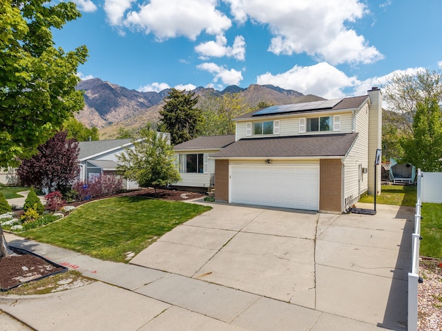 7123 S Watermill Way, Cottonwood Heights, UT 84121 - view of front facade with a front yard, a chimney, roof mounted solar panels, concrete driveway, and a mountain view