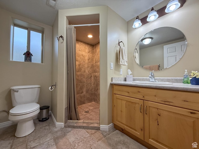 bathroom with vanity, visible vents, toilet, baseboards, and a shower stall