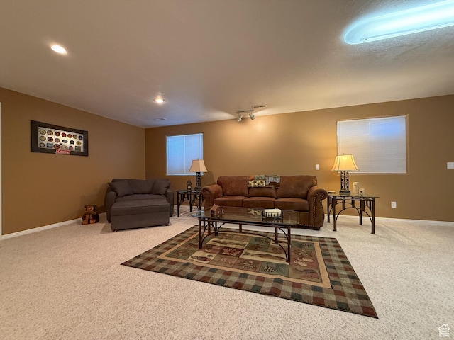 carpeted living area featuring baseboards and recessed lighting