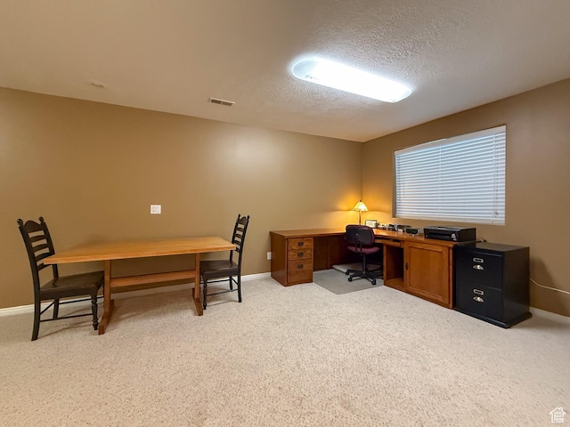 home office featuring baseboards, light carpet, a textured ceiling, and visible vents