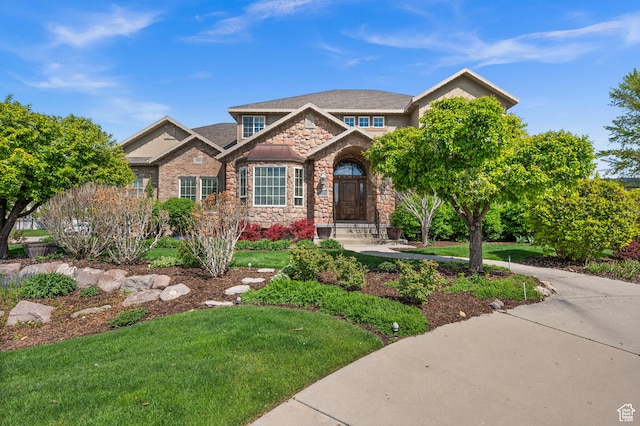 craftsman inspired home with stone siding and a front lawn