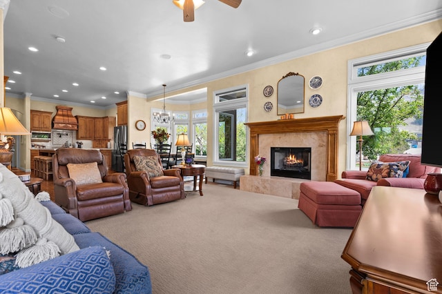 carpeted living room featuring recessed lighting, ornamental molding, ceiling fan with notable chandelier, and a fireplace