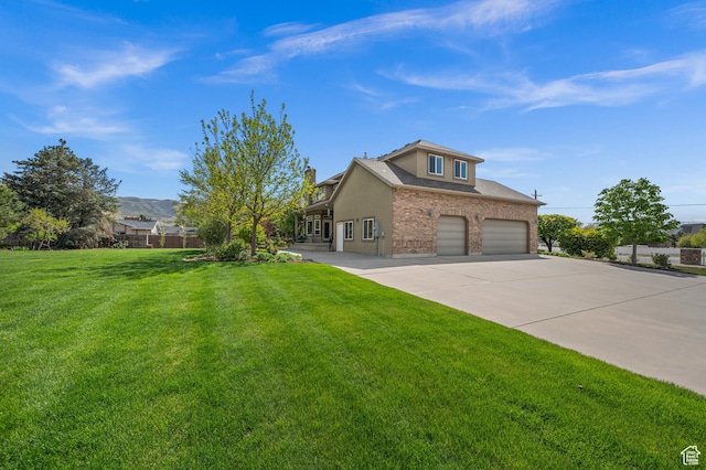 view of front of property featuring an attached garage, brick siding, stucco siding, a front yard, and concrete driveway