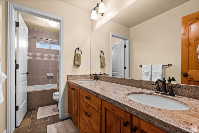 full bathroom featuring double vanity, tiled shower / bath, a sink, and tile patterned flooring