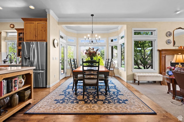 dining area featuring an inviting chandelier, baseboards, ornamental molding, and wood finished floors