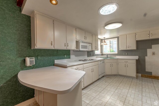 81 S 700 E, Bountiful, UT 84010 - kitchen featuring a peninsula, white appliances, light countertops, white cabinets, and a sink