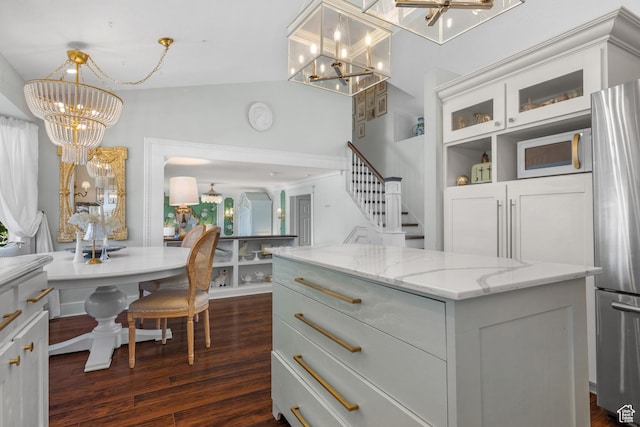 5472 W Aristada Ave S, West Jordan, UT 84081 - kitchen with freestanding refrigerator, light stone countertops, dark wood finished floors, and a notable chandelier