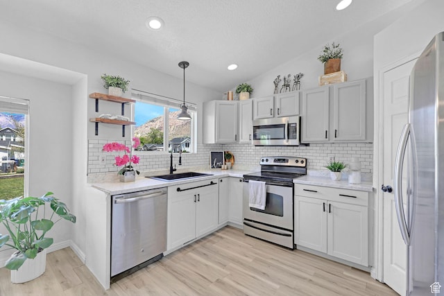 706 E 425 S, Ogden, UT 84404 - kitchen featuring stainless steel appliances, light wood-type flooring, a sink, and tasteful backsplash