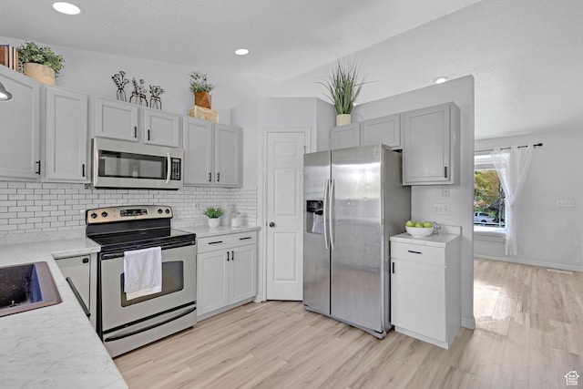 706 E 425 S, Ogden, UT 84404 - kitchen with light wood-style floors, decorative backsplash, light countertops, and stainless steel appliances