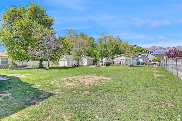 706 E 425 S, Ogden, UT 84404 - view of yard with a storage shed, a garage, a fenced backyard, an outbuilding, and a mountain view