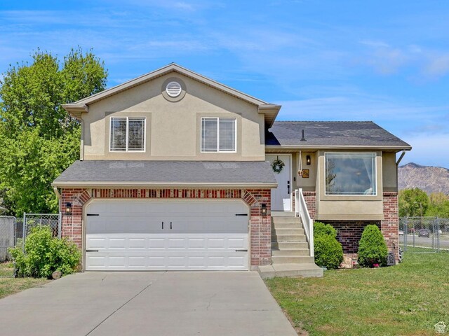 706 E 425 S, Ogden, UT 84404 - tri-level home with brick siding, a garage, concrete driveway, and stucco siding
