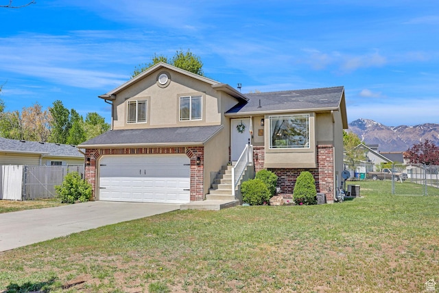 706 E 425 S, Ogden, UT 84404 - tri-level home featuring a garage, a front lawn, fence, stucco siding, and concrete driveway