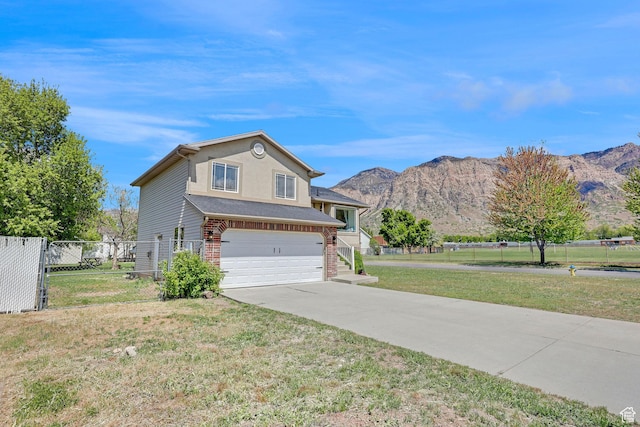 706 E 425 S, Ogden, UT 84404 - view of front facade with fence, a mountain view, a front lawn, concrete driveway, and an attached garage