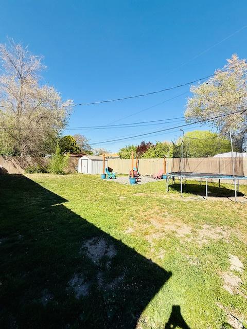 2861 S 3095 W, West Valley City, UT 84119 - view of yard with a fenced backyard, a trampoline, an outbuilding, and a storage shed