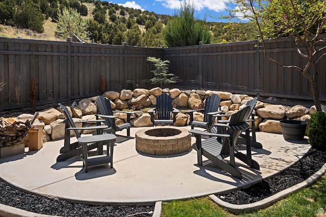 4126 E Cherokee, Eagle Mountain, UT 84005 - view of patio / terrace with a fenced backyard, an outdoor fire pit, and a forest view