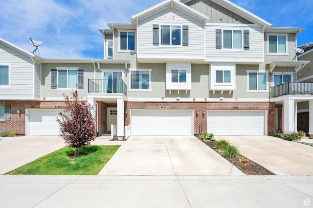 multi unit property featuring an attached garage, board and batten siding, and driveway