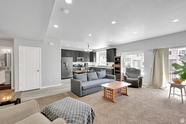 living area featuring baseboards, recessed lighting, and a notable chandelier
