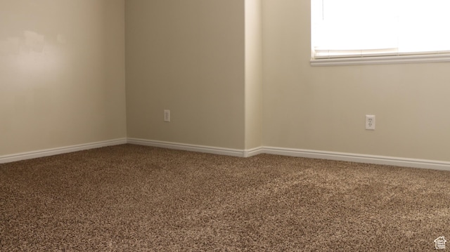 carpeted spare room with baseboards