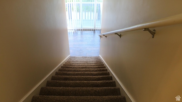 stairway featuring baseboards and wood finished floors