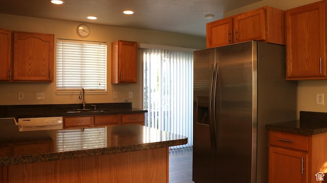 kitchen with stainless steel fridge, dishwashing machine, a sink, and a wealth of natural light