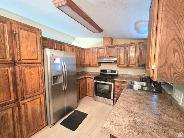 1177 W 1960 S, Logan, UT 84321 - kitchen featuring a sink, brown cabinetry, stainless steel appliances, under cabinet range hood, and vaulted ceiling