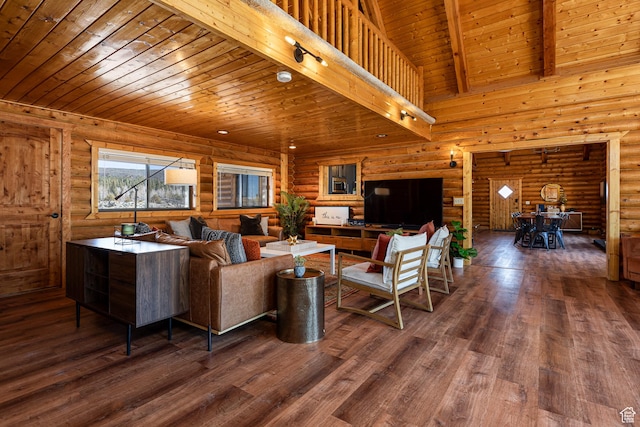 living area featuring beamed ceiling, log walls, wood ceiling, and wood finished floors