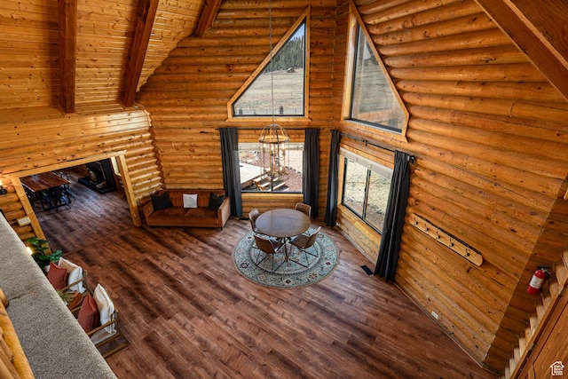 living area with wooden ceiling, rustic walls, beam ceiling, and wood finished floors