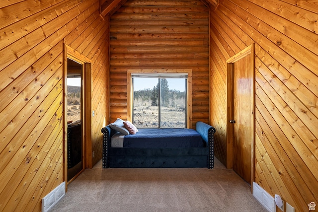 bedroom with carpet floors, visible vents, and log walls