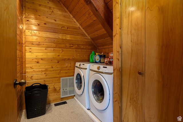 laundry area with washing machine and clothes dryer, wooden walls, laundry area, carpet, and wooden ceiling