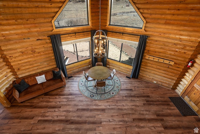 room details featuring log walls, wood finished floors, and a chandelier