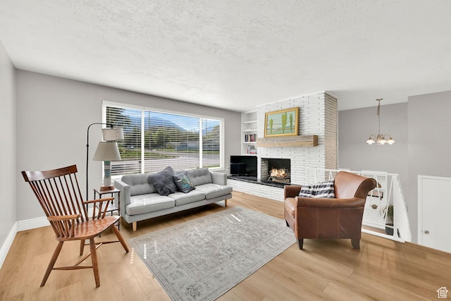 507 N 200 W, Brigham City, UT 84302 - living area with a brick fireplace, a textured ceiling, a chandelier, and light wood-style flooring
