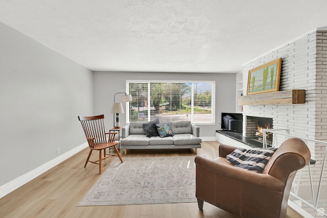 507 N 200 W, Brigham City, UT 84302 - living room with baseboards, a fireplace, light wood-type flooring, and a textured ceiling