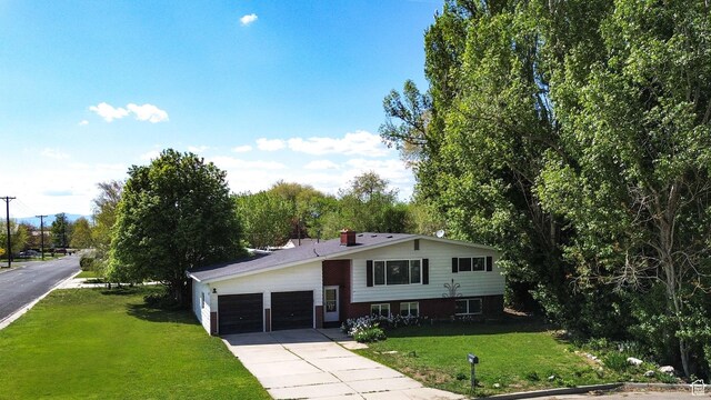 507 N 200 W, Brigham City, UT 84302 - view of front of home with a chimney, a garage, driveway, and a front yard