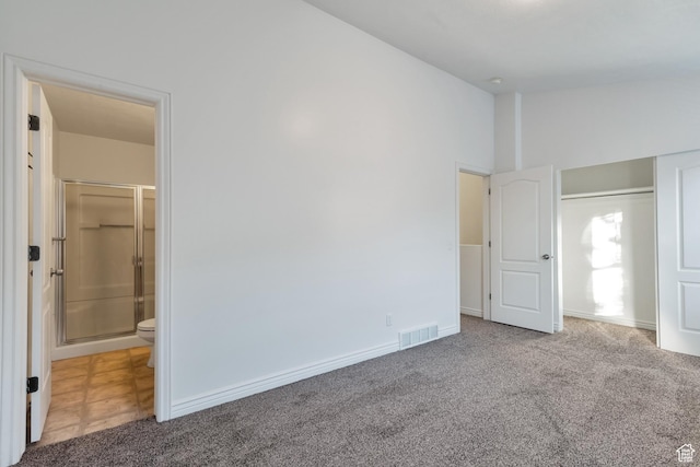 unfurnished bedroom featuring carpet floors, baseboards, visible vents, and ensuite bath