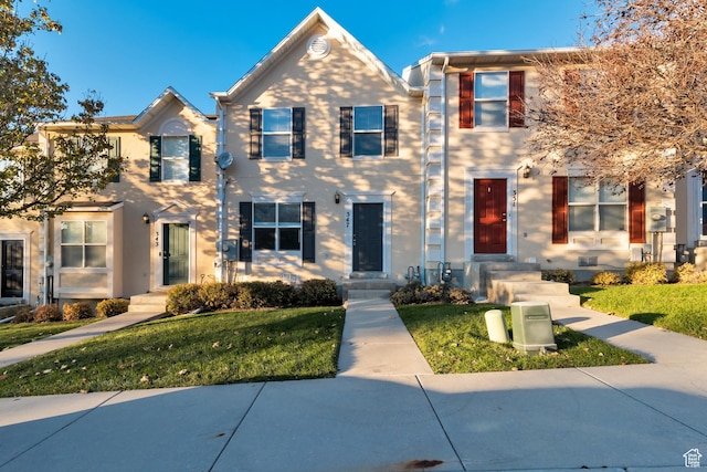 view of property featuring stucco siding and a front yard