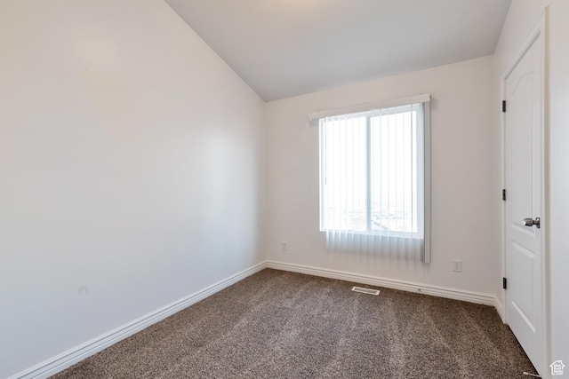 unfurnished bedroom with carpet flooring, baseboards, vaulted ceiling, and visible vents