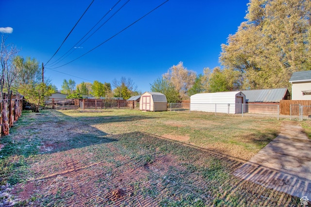 view of yard with a fenced backyard, an outbuilding, and a storage shed